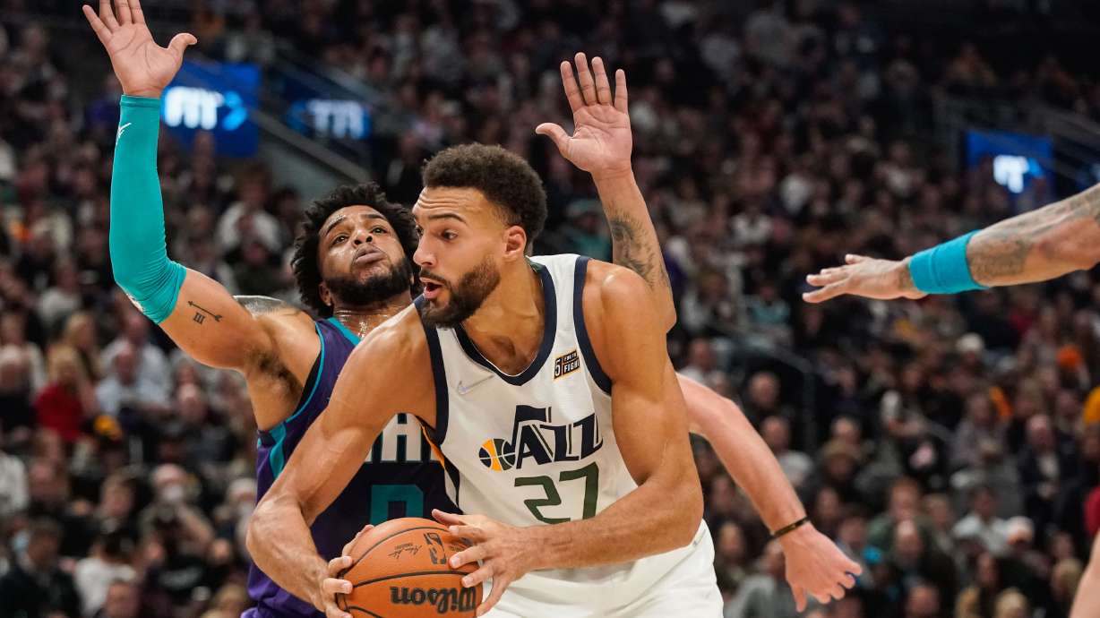 Utah Jazz center Rudy Gobert (27) goes past Charlotte Hornets defenders during an NBA game at Vivint Arena in Salt Lake City on Monday, Dec. 20, 2021.