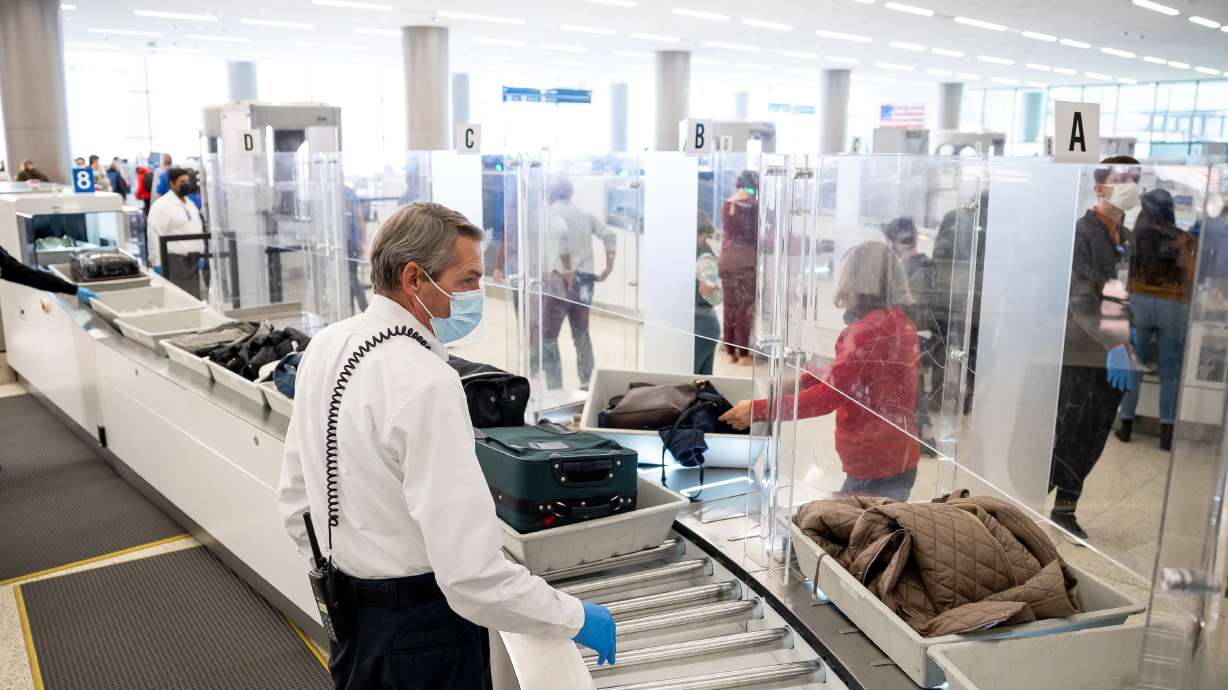 TSA officer Matthew Yeates helps travelers at the security checkpoint at Salt City Lake International Airport in Salt Lake City on Nov. 18. Airport travel is expected to pick up Wednesday, Thursday and Friday ahead of Christmas.