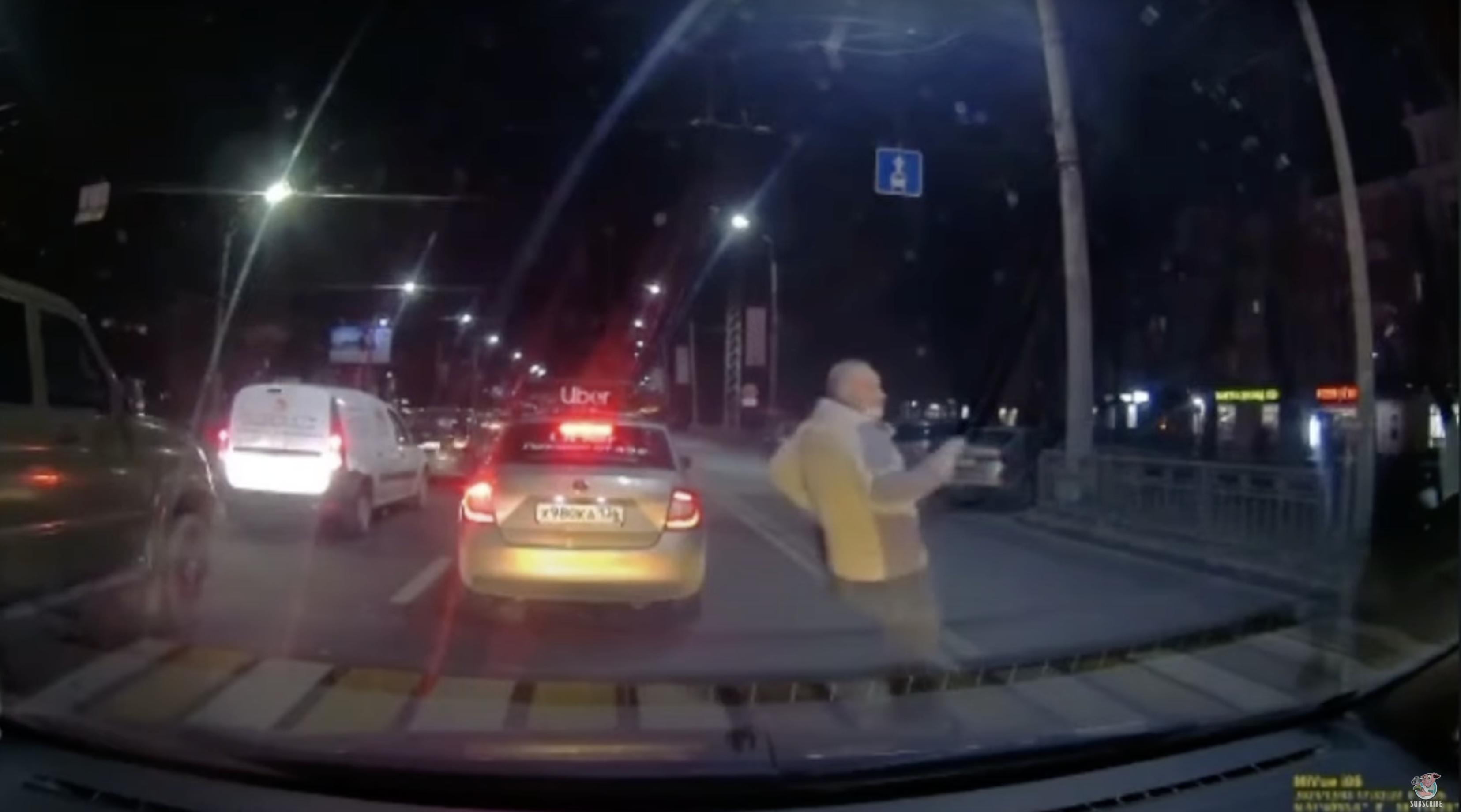 Video shows the moment before a pedestrian crossing a busy road narrowly avoids getting hit by a bus.