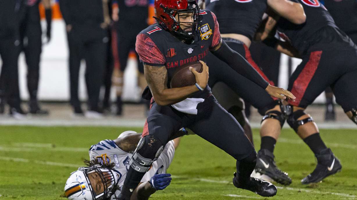 San Diego State quarterback Lucas Johnson (7) avoids a tackle during the first half of the Frisco Bowl NCAA college football game against UTSA, Tuesday, Dec. 21, 2021, in Frisco, Texas.