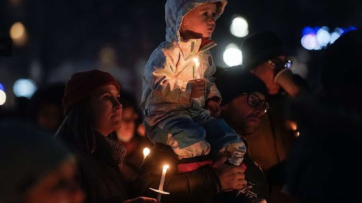 Cameron Diachun, 3, center, Nick Diachun, right, and Jaime Diachun listen to the speakers at the 2021 Homeless Persons Memorial Candlelight Vigil at Pioneer Park in Salt Lake City on Tuesday. The vigil honored the 117 men and women who died in Salt Lake City while experiencing homelessness over the past year.