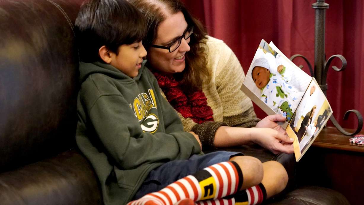 Nicole Olson and her son Porter, 10, look at his baby pictures at their home, Dec. 17, in Phoenix. Porter was relinquished at birth through what's known as a safe haven law.
