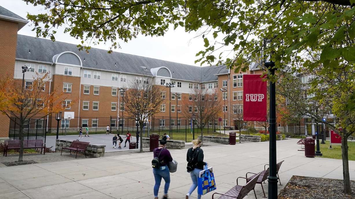 Students walk on the campus of Indiana University of Pennsylvania in Indiana, Pa., Oct. 21, 2020. The Biden administration on Wednesday extended a student loan moratorium through May 1, 2022.