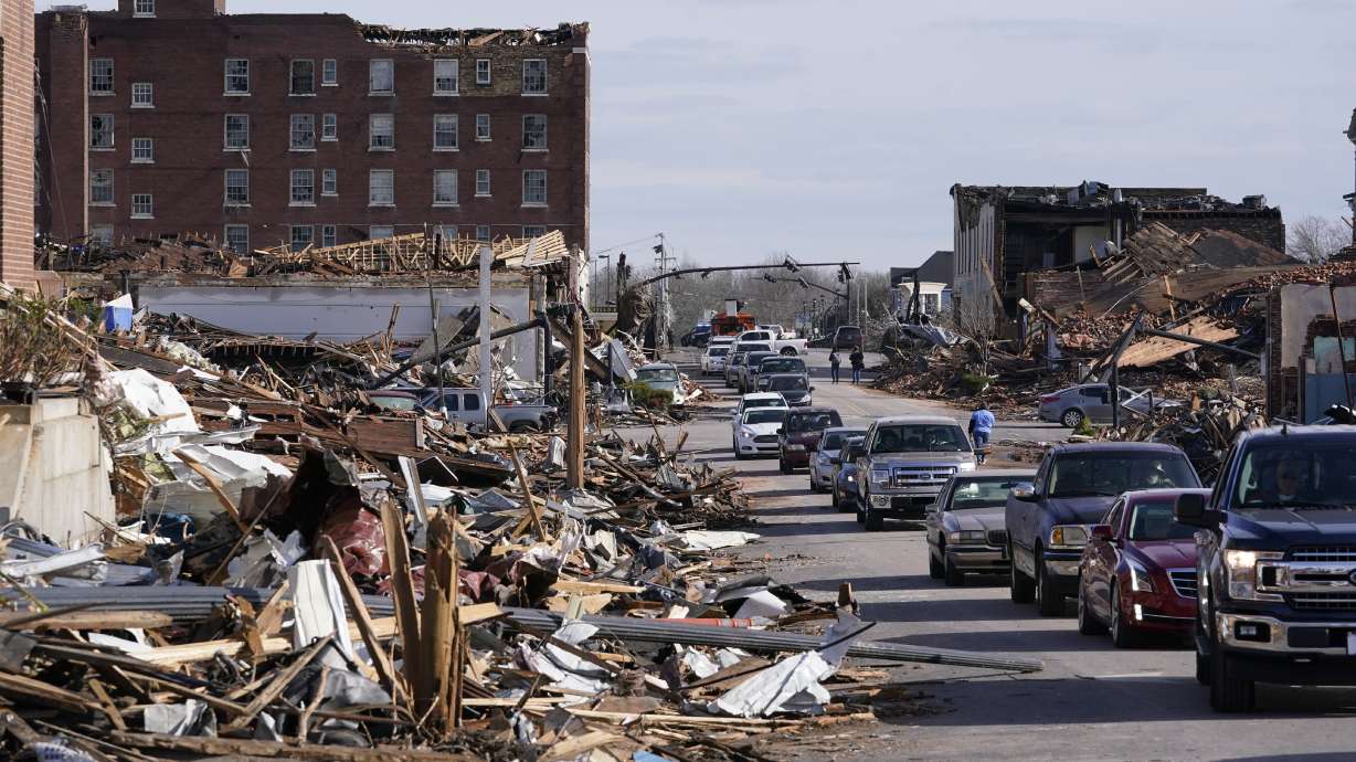 People survey damage from a tornado is seen in Mayfield, Ky., on Saturday, Dec. 11. Nine days after the tornado, a cat was found in the rubble of a building.