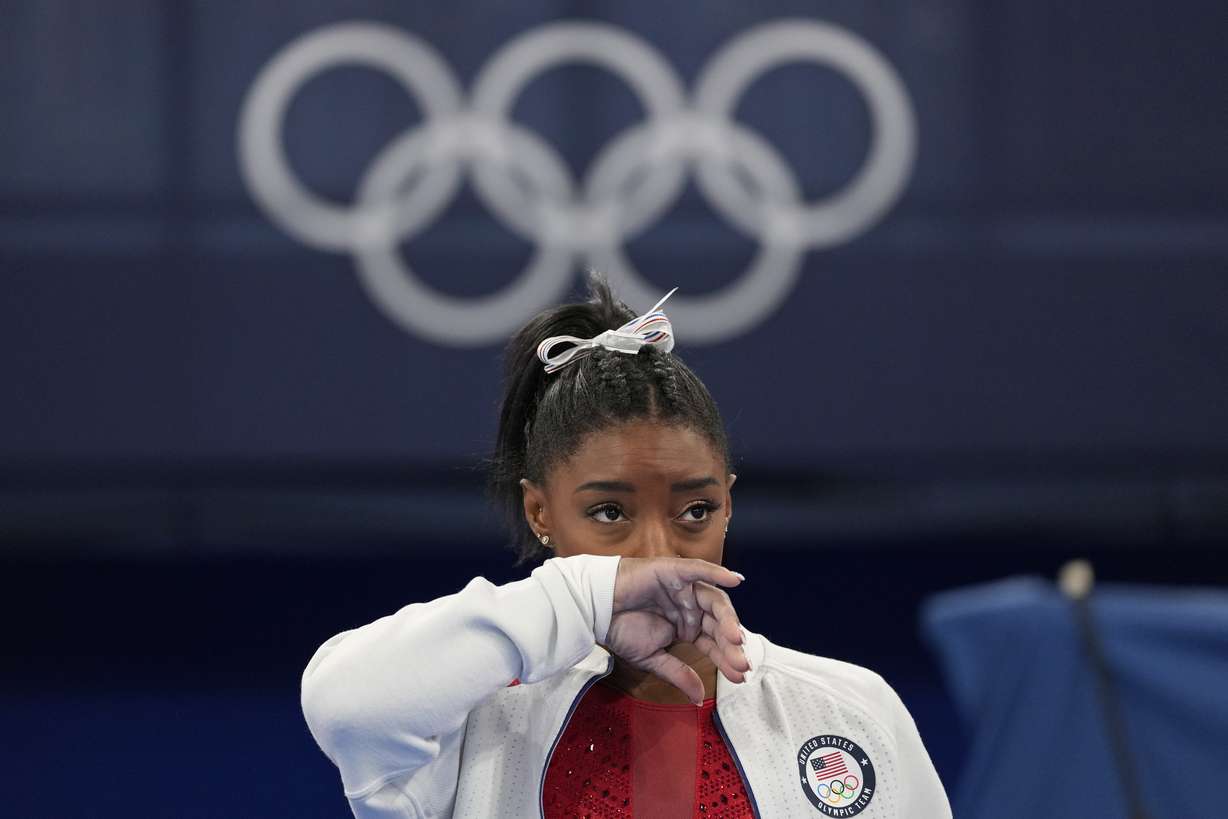 Simone Biles, of the United States, watches gymnasts perform at the 2020 Summer Olympics, Tuesday, July 27, 2021, in Tokyo. Biles says she wasn't in the right 'headspace' to compete and withdrew from gymnastics team final to protect herself.