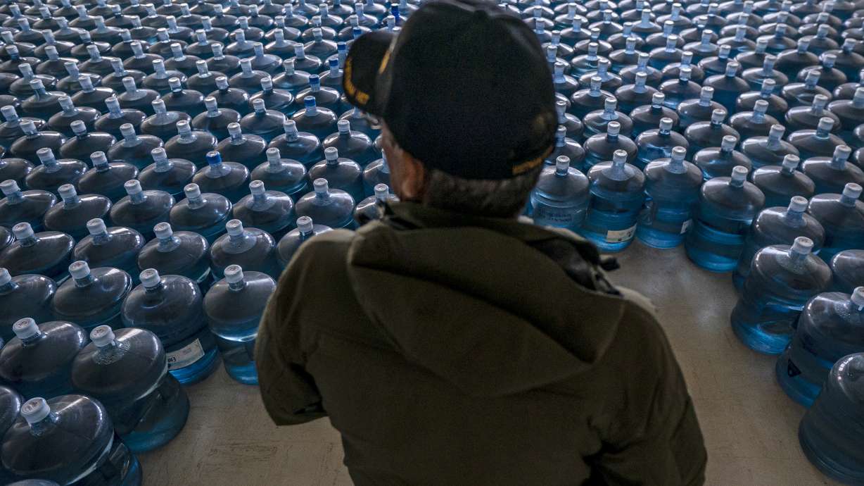 Dan Martinez, emergency manager for the Confederated Tribes of Warm Springs, pauses in a classroom used to store donated water on Tuesday, Dec. 7, 2021, in, Warm Springs, Ore. In Oregon, tribal officials have handed out about 3 million gallons of water — almost all of it donated — from a decommissioned elementary school on the reservation.