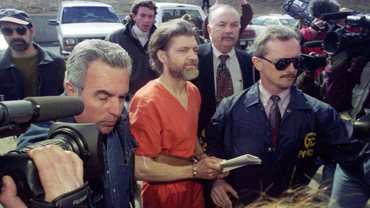 Ted Kaczynski is guided to his arraignment by federal marshals in Helena, Montana, on April 4, 1996. Four of the bombings committed by Kaczynski, who died in federal prison Saturday at age 81, had ties back to Utah.