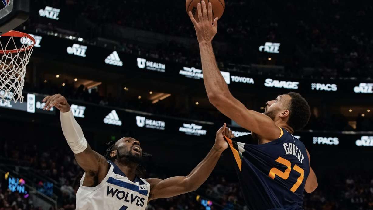 Utah Jazz center Rudy Gobert, right, jumps to score as Minnesota Timberwolves guard Jaylen Nowell attempts to defend during an NBA game at Vivint Arena in Salt Lake City on Thursday, Dec. 23, 2021.