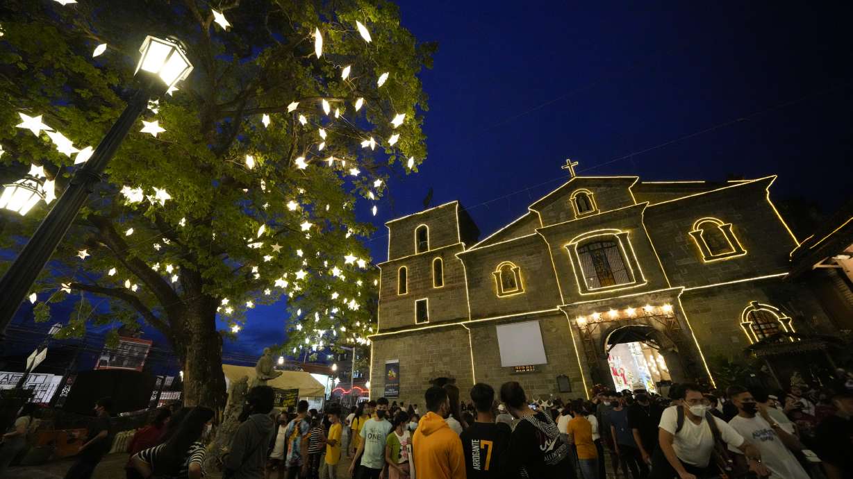 Residents wearing face masks as a safety measure to curb the spread of the coronavirus walks outside the St. Joseph Parish Church after attending the first of nine daily dawn masses before Christmas day in suburban Las Pinas city, the Philippines on Thursday, Dec. 16.