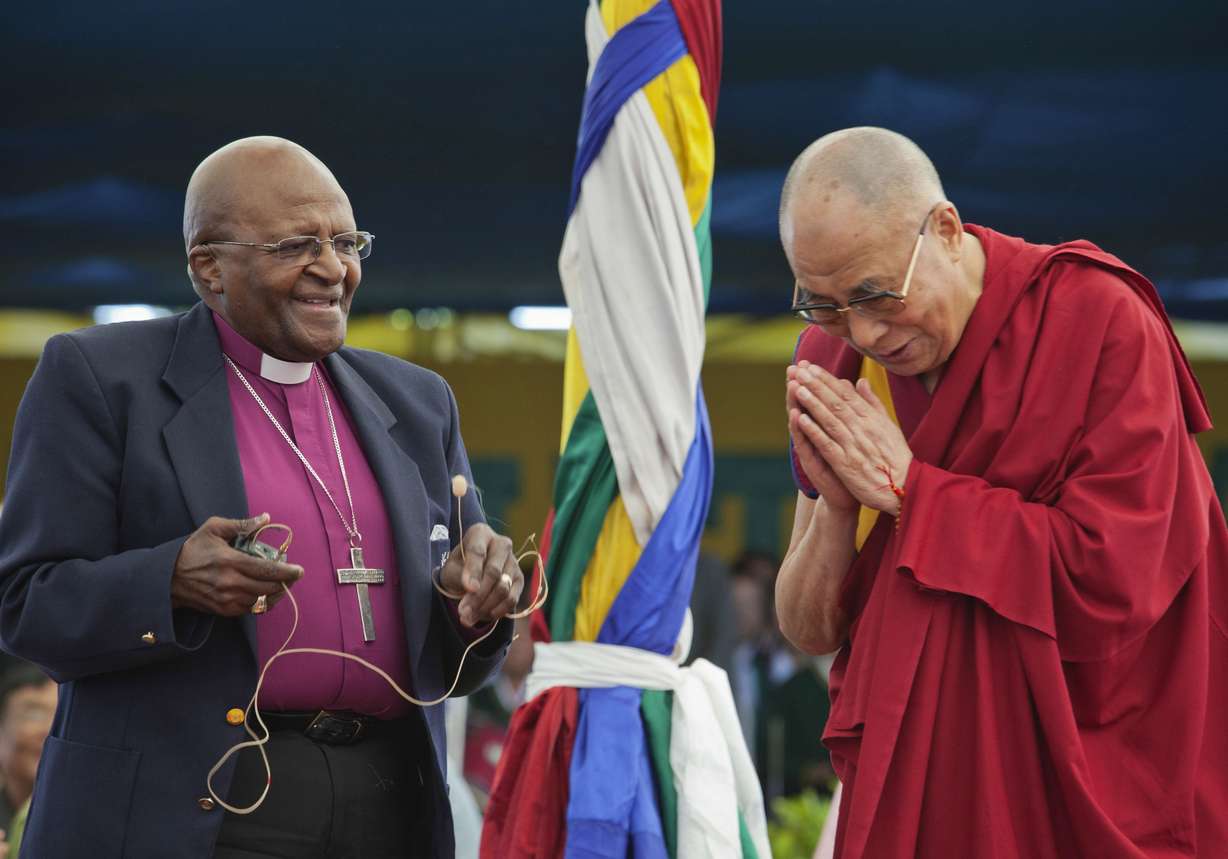 Anglican Archbishop Emeritus Desmond Tutu, left, holds a microphone as Tibetan spiritual leader the Dalai Lama gestures, in Dharmsala, India, April 23, 2015.