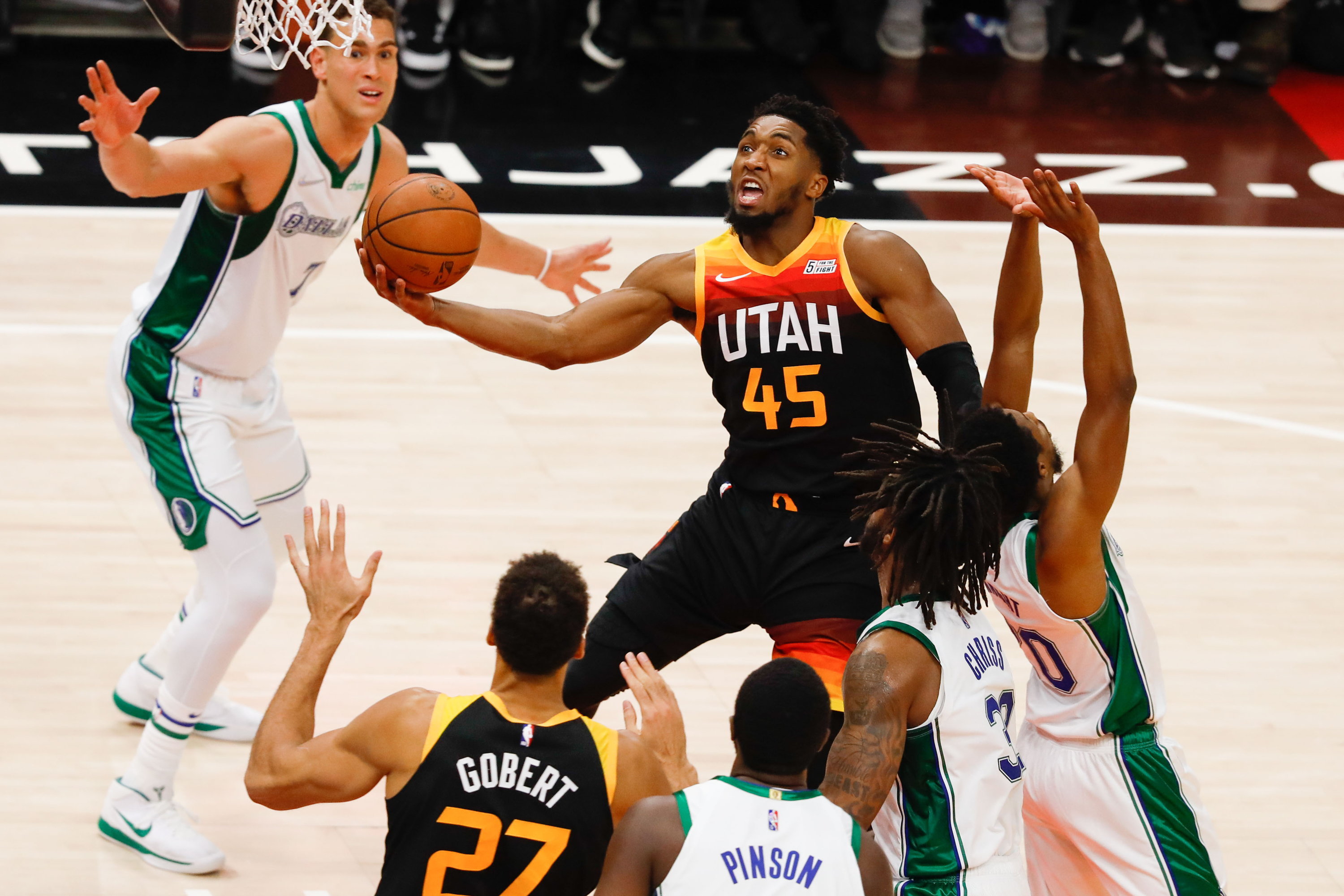 Utah Jazz guard Donovan Mitchell, center, attempts the score past Dallas Mavericks defenders during an NBA game at Vivint Arena in Salt Lake City on Saturday, Dec. 25, 2021.
