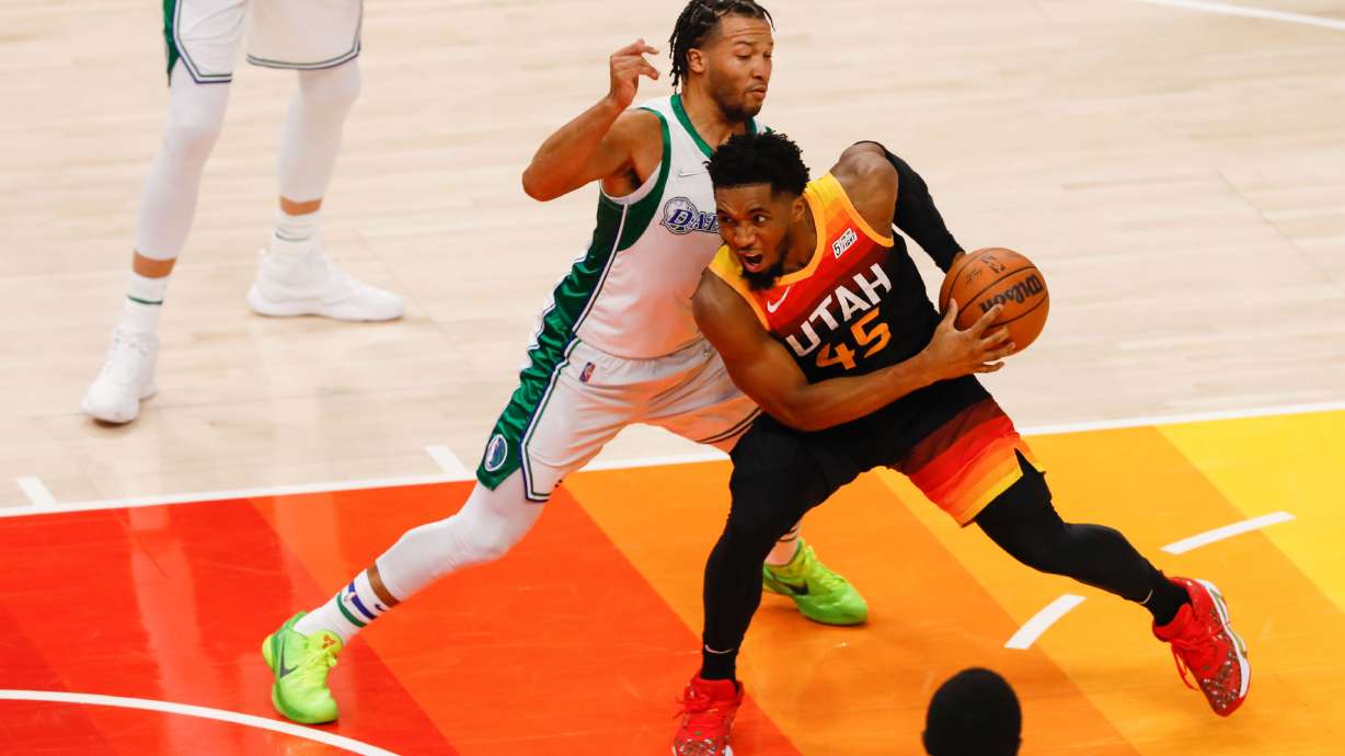 Utah Jazz guard Donovan Mitchell, right goes past Dallas Mavericks guard Jalen Brunson during an NBA game at Vivint Arena in Salt Lake City on Saturday, Dec. 25, 2021.