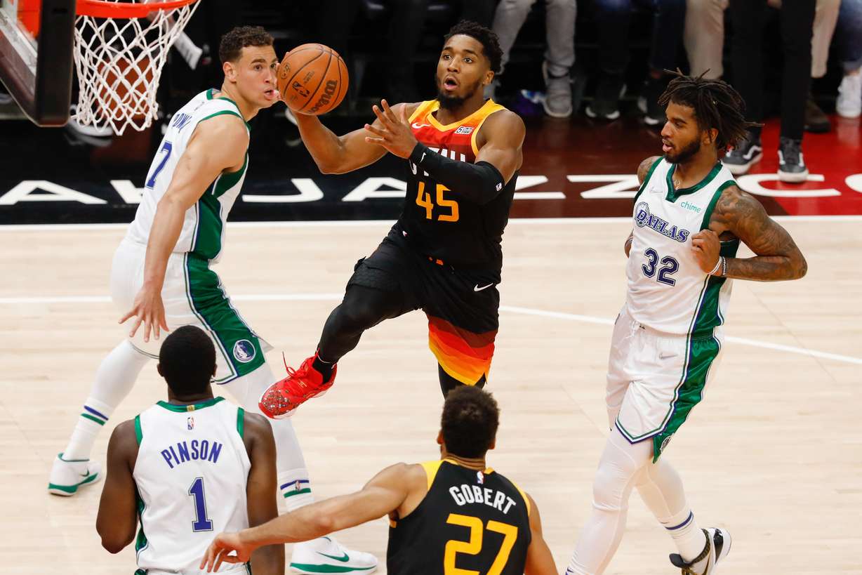 Utah Jazz guard Donovan Mitchell, center, attempts the score past Dallas Mavericks defenders during an NBA game at Vivint Arena in Salt Lake City on Saturday, Dec. 25, 2021.