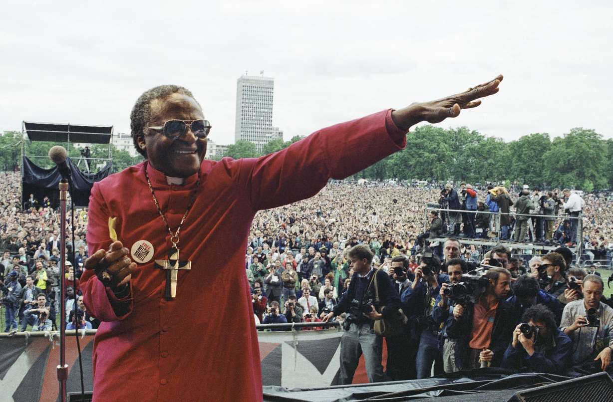 Archbishop Desmond Tutu smiles as he gestures from the platform during the Nelson Mandela Freedom Rally in London's Hyde Park, July 17, 1988 – on the eve of the jailed African National Congress leader's 70 birthday.