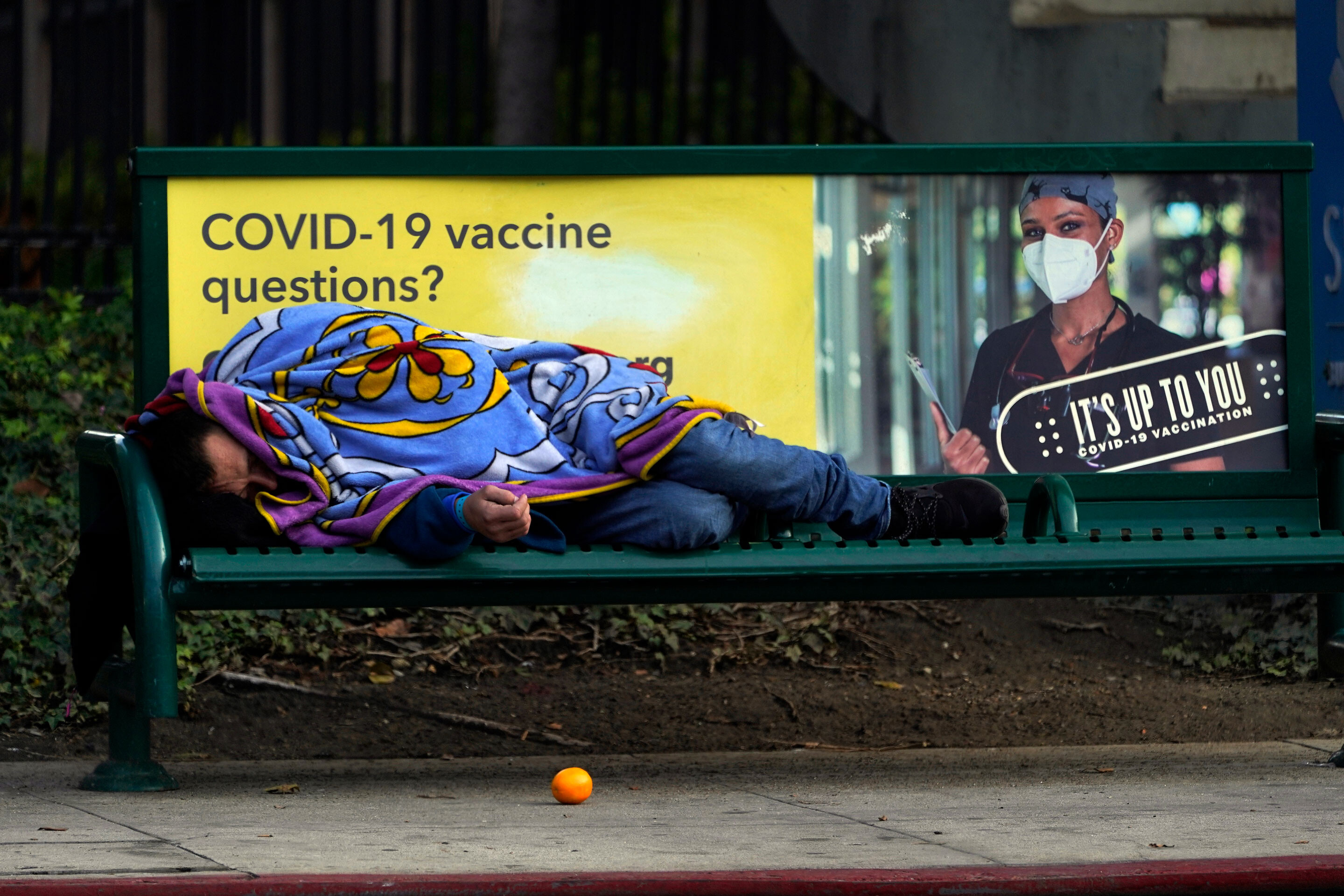 A homeless person sleeps on a bench in downtown Los Angeles, Wednesday, Dec. 15.