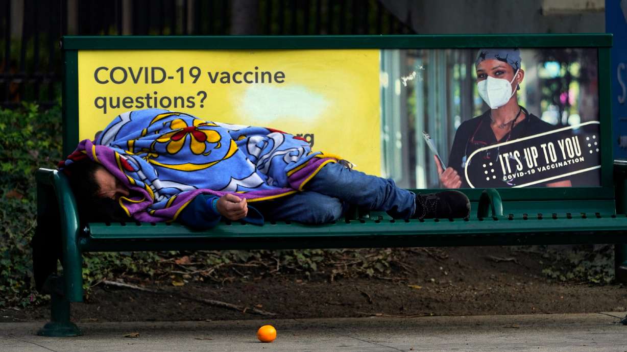 A homeless person sleeps on a bench in downtown Los Angeles, Wednesday, Dec. 15.