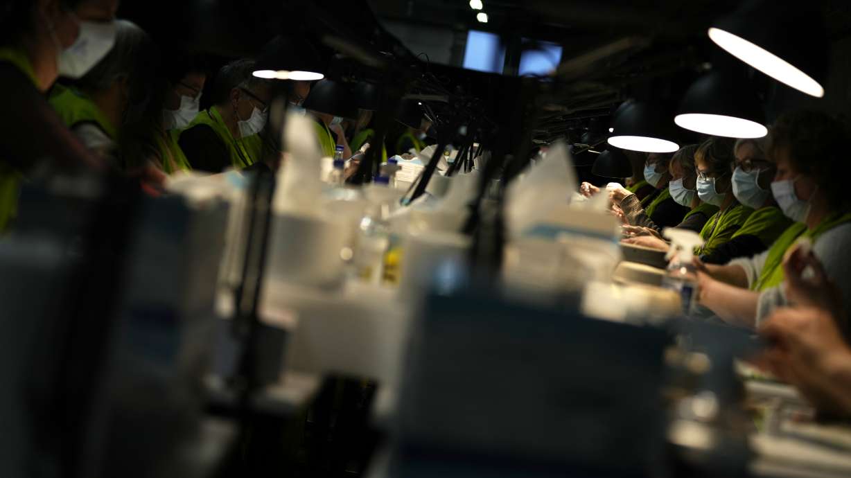 Pharmacists fill syringes from vials of the Moderna booster vaccine at the Antwerp Expo vaccine center in Antwerp, Belgium on Monday. In Belgium, many flocked to their local vaccine center to receive their booster shots and stay ahead of the surging omicron infections.