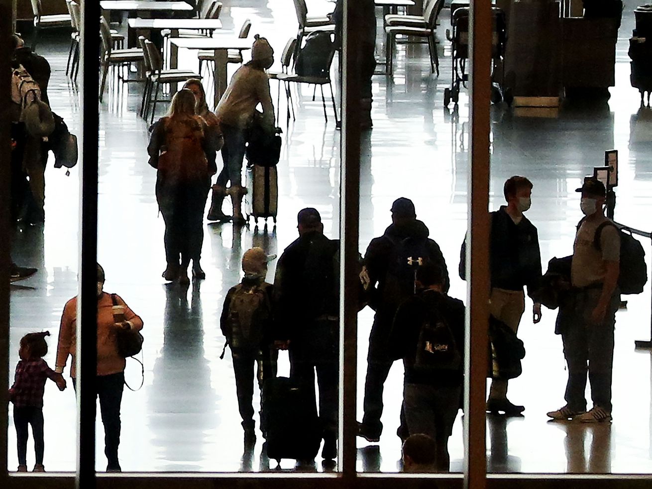 People walk through the Salt Lake City International Airport on March 11. This year a wave of COVID-19 induced cancellations and delays has upended travel plans for thousands.