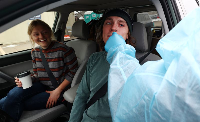 Lindsey Ostermiller, left, watches as Jared Badger
receives a COVID-19 test outside of the Utah Department of Health
in Salt Lake City on Monday. People had to wait in
long lines in order to be tested.