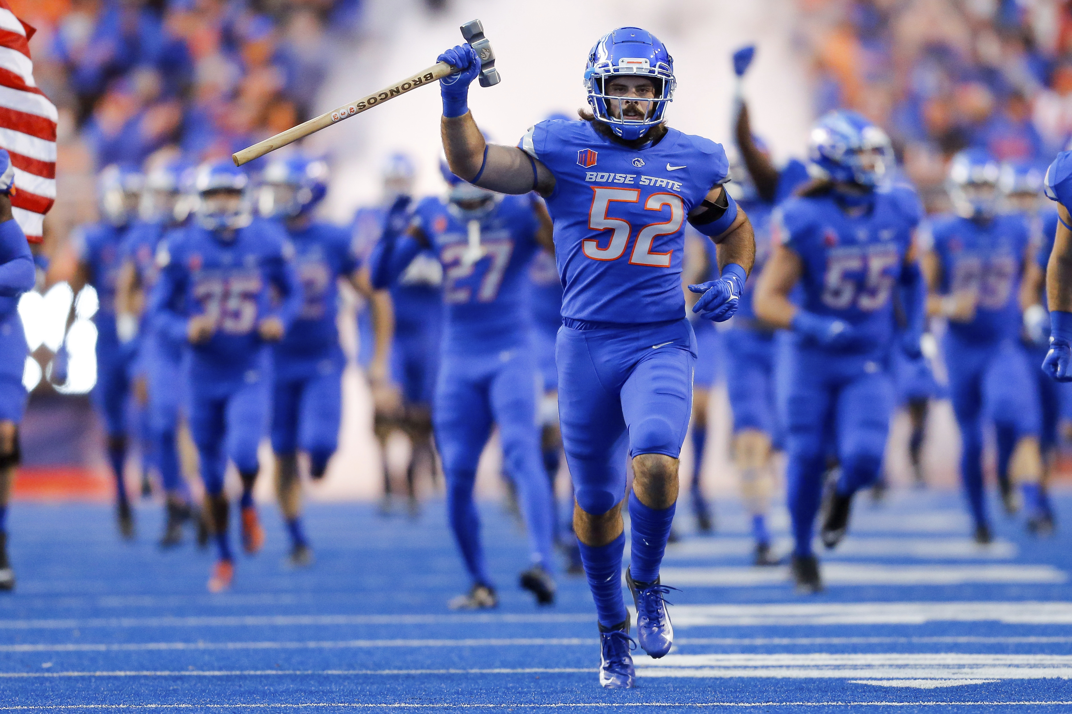 Boise State linebacker DJ Schramm (52), carrying the Dan Paul Hammer, leads Boise State onto the field before an NCAA college football game against Oklahoma State on Sept. 18, 2021, in Boise, Idaho. The Broncos are 8-4 all-time against BYU, including a 5-1 mark in Boise.