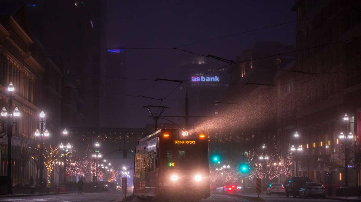 A Utah Transit Authority TRAX rail car's light shines through a snow squall in downtown Salt Lake City early Monday evening. It was the first time Salt Lake City was included in a snow squall warning, according to the National Weather Service.