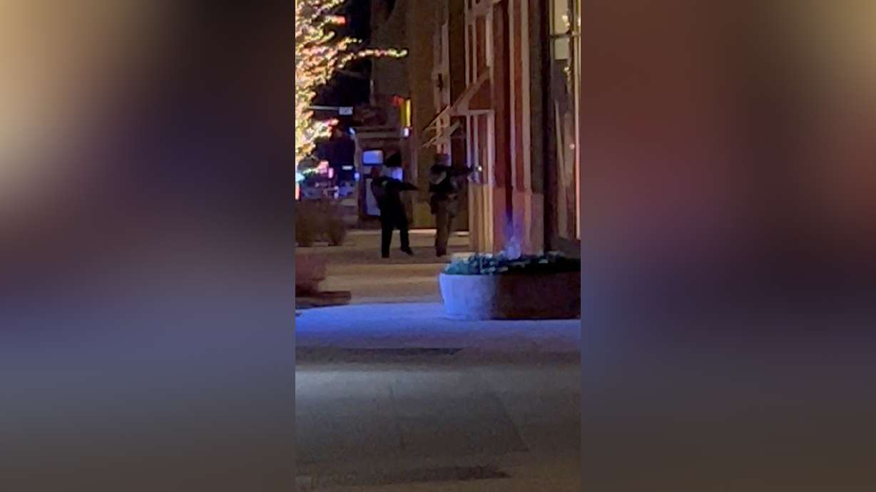 Armed officers stand outside a building in Lakewood, Colo., Monday. A gunman killed four people and injured an officer, police said.