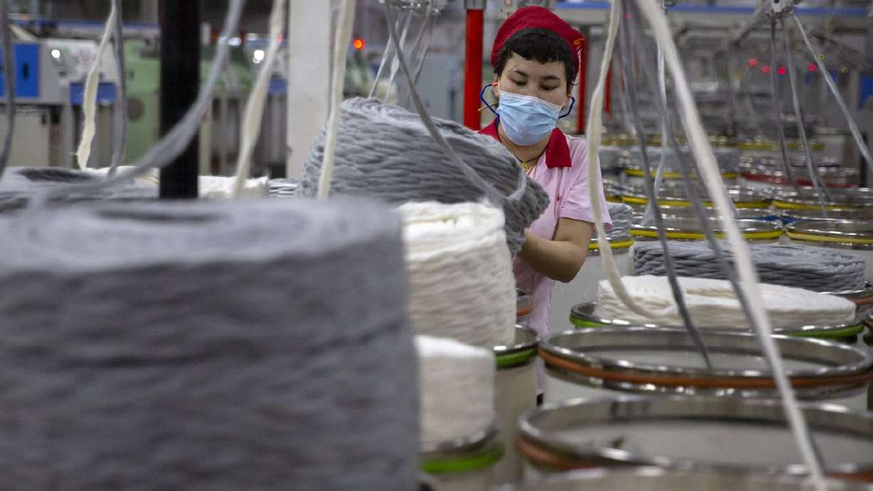 A worker gathers cotton yarn at a textile manufacturing plant in Aksu in western China’s Xinjiang Uyghur Autonomous Region, on April 20. President Joe Biden signed into law just before Christmas a bipartisan bill banning goods from China's Xinjiang region unless companies can prove they aren't made with forced labor.