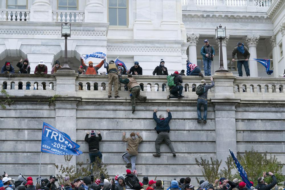Violent insurrectionists loyal to then-President Donald Trump climb the west wall of the U.S. Capitol in Washington, Jan. 6. On Tuesday, the Jan. 6 committee agreed to shield some documents.