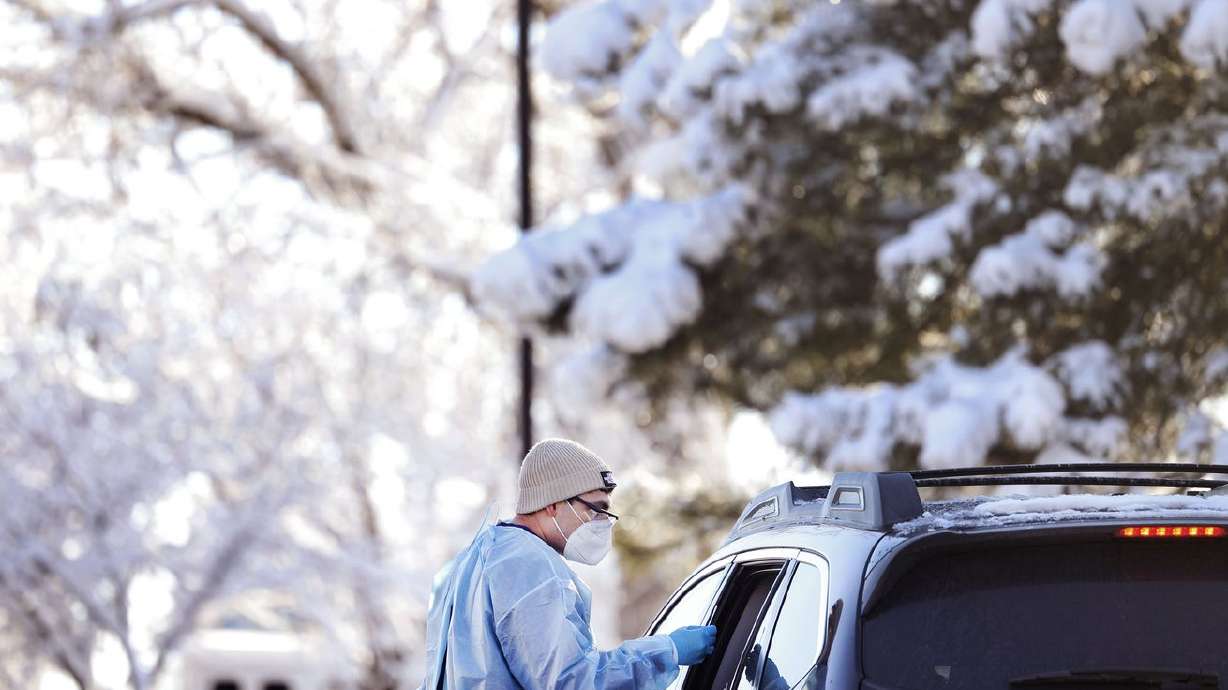 Javanni Alzayyat administers a COVID-19 test at the Cannon Health Building in Salt Lake City on Dec. 15. Will a second booster be recommended because of the omicron variant?