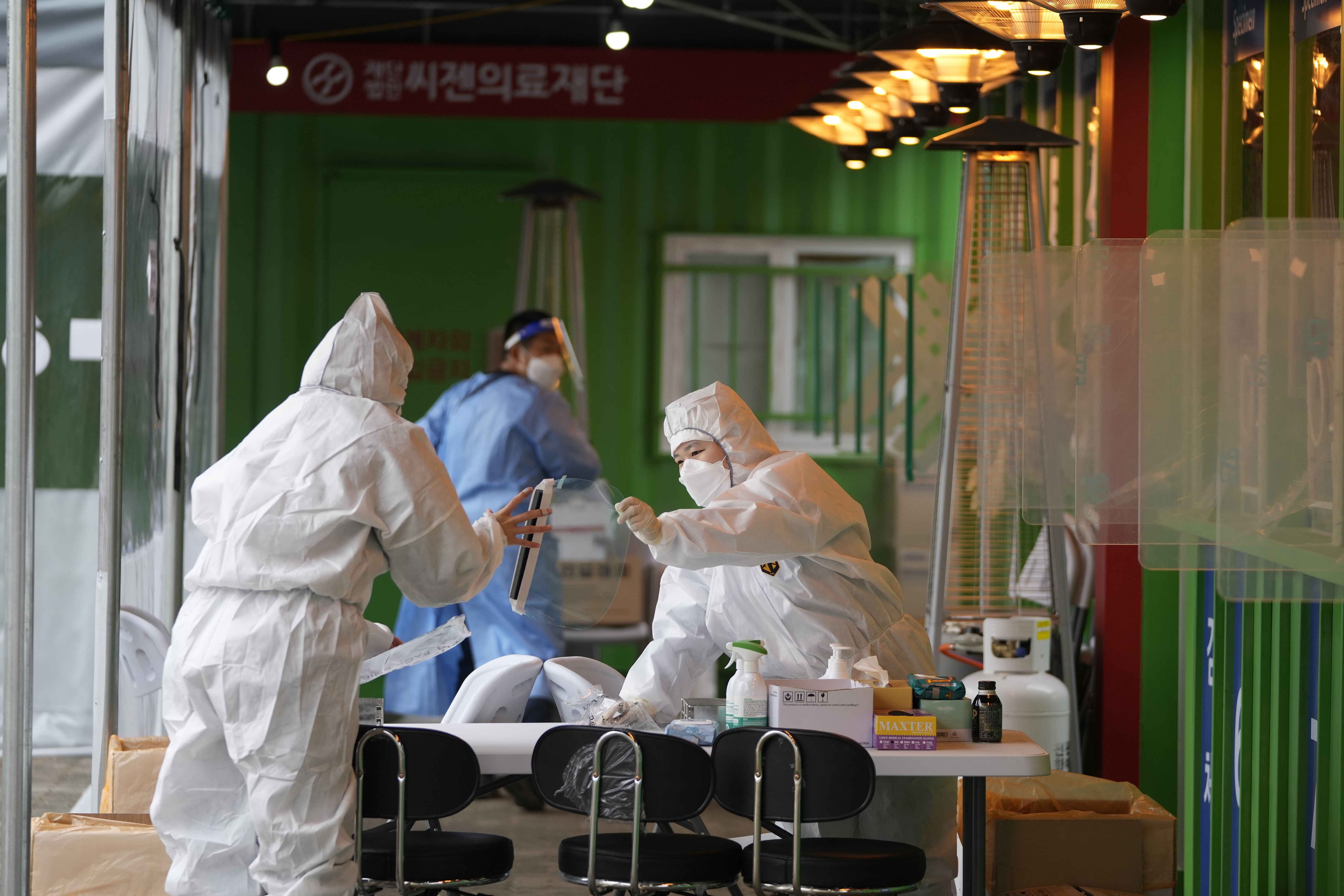 Medical workers wearing protective gear prepare to take samples at a temporary screening clinic for the coronavirus in Seoul, South Korea, Wednesday. The number of COVID-19 cases recorded worldwide increased by 11% last week.