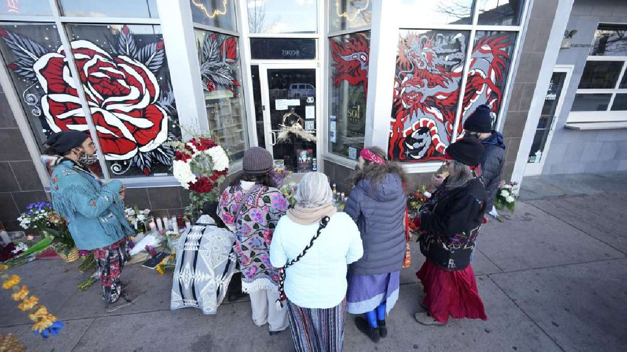 Mourners gather outside the door of a tattoo parlor along South Broadway, Tuesday in Denver, one of the scenes of a shooting spree that left six people dead—including the suspected shooter Monday evening — and left two more people wounded.