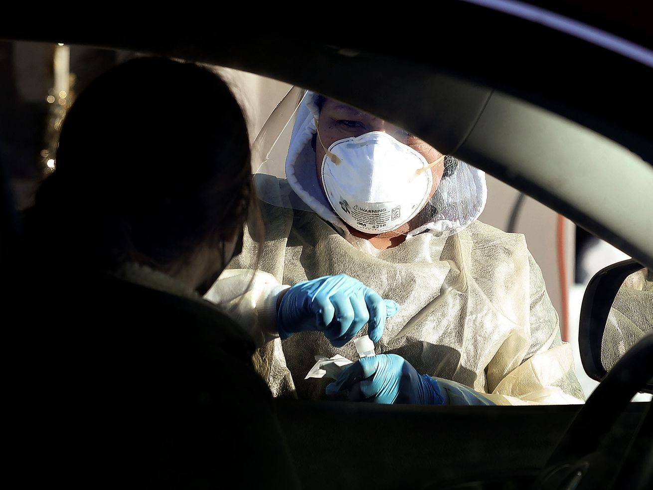 Diana Cuence speaks to a person about a COVID-19 test at the Cannon Health Building in Salt Lake City on Dec. 15.