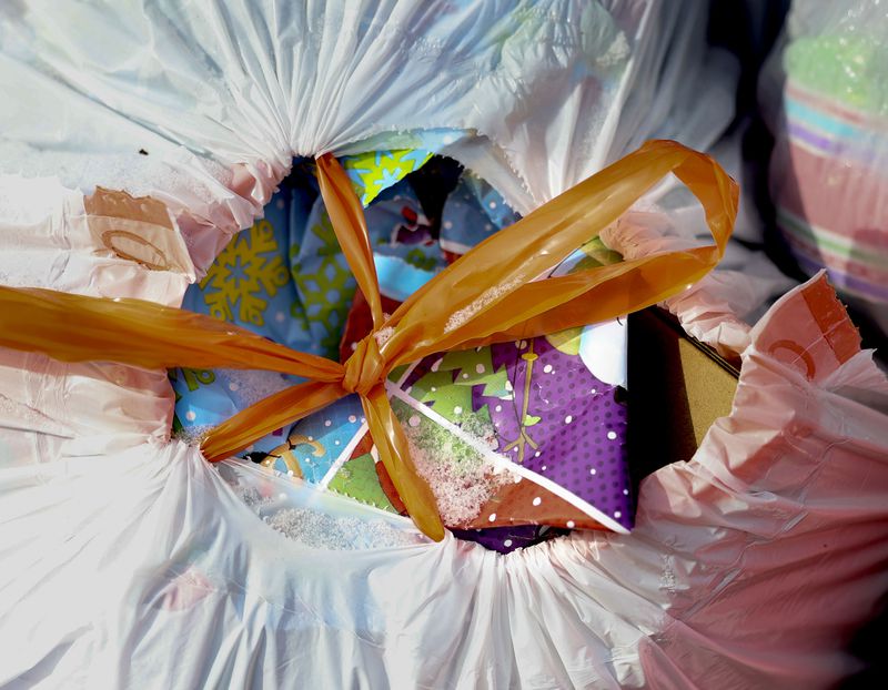 Wrapping paper stuffed into a plastic bag sits in a recycling bin in Herriman on Wednesday. Recyclables should not be enclosed in plastic bags. This will prevent your items from being recycled.