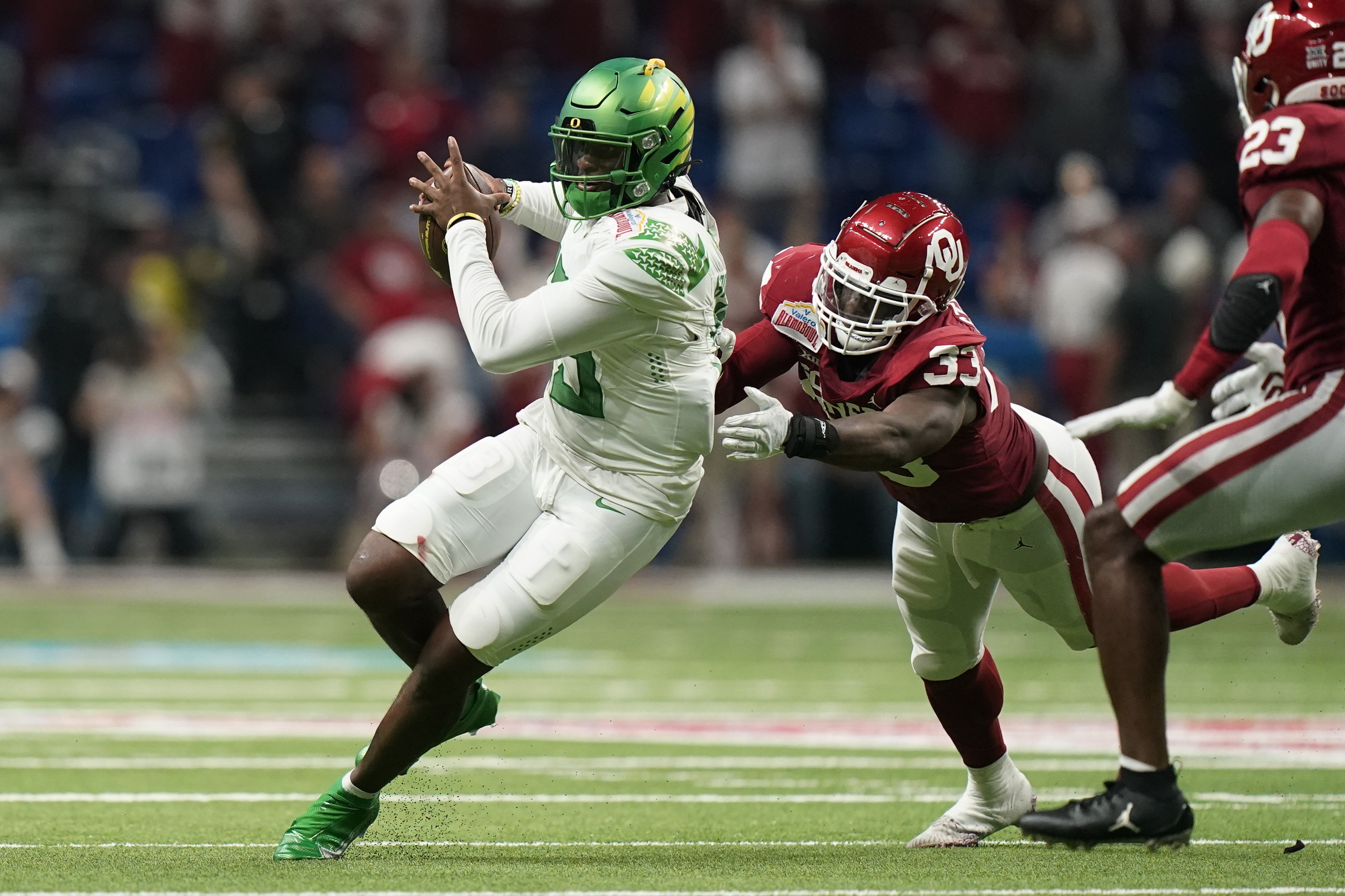 Oregon quarterback Anthony Brown (13) is sacked by Oklahoma linebacker Marcus Stripling (33) during the first half of the Alamo Bowl NCAA college football game Wednesday, Dec. 29, 2021, in San Antonio.