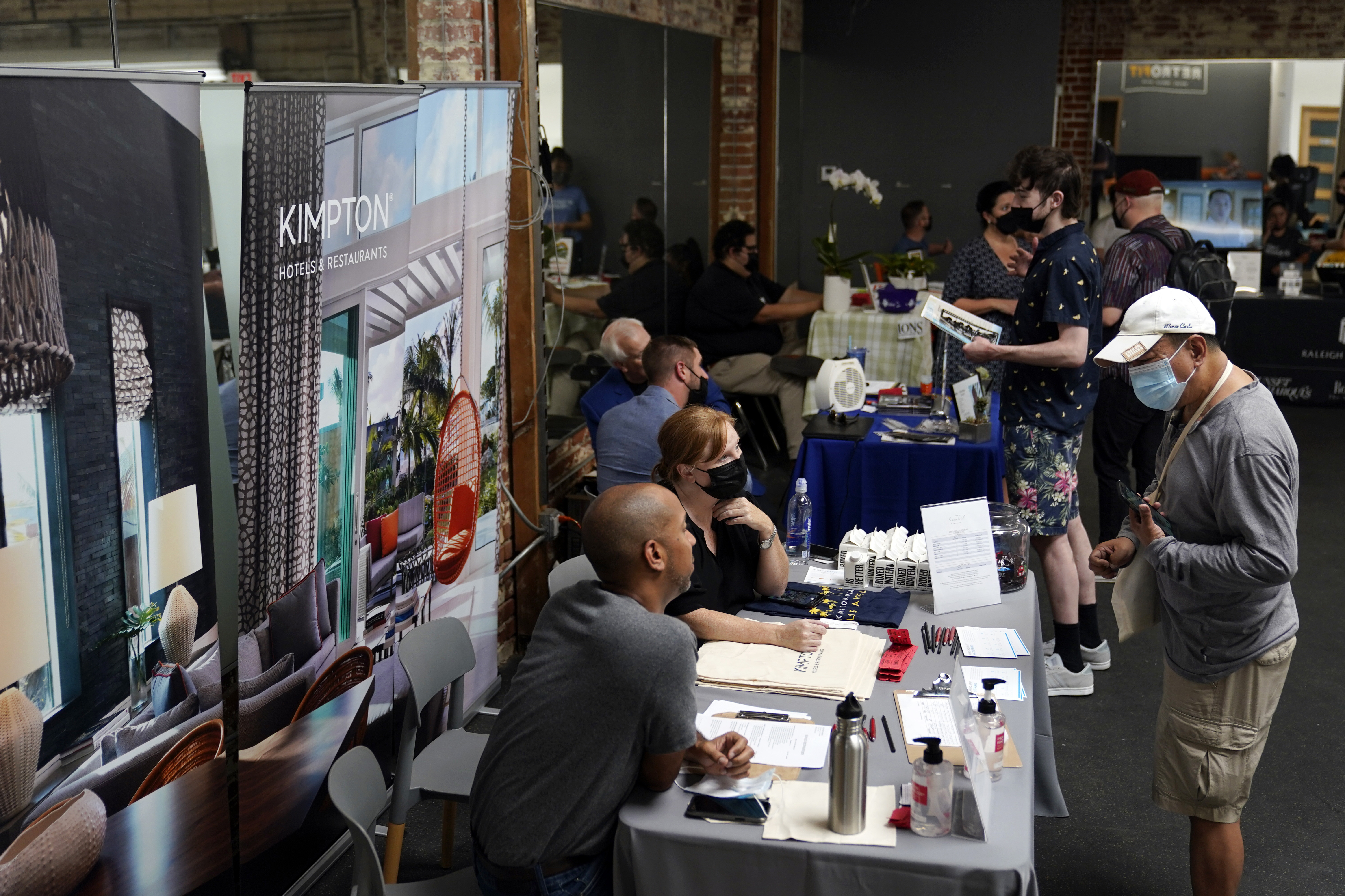 Prospective employers and job seekers interact during a job fair on Sept. 22 in Los Angeles. The number of Americans applying for unemployment benefits fell below 200,000 last week.
