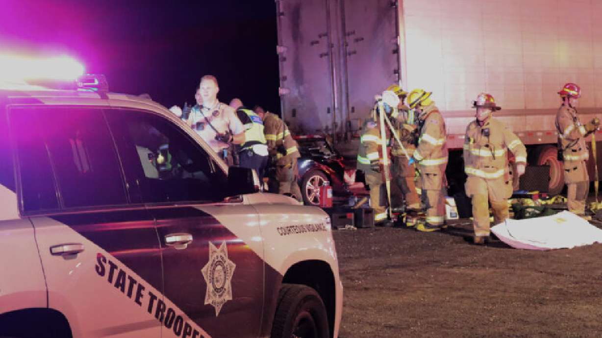 A Mustang slides under a semitractor-trailer during a crash on southbound Interstate 15 just south of the Utah-Arizona border, Mohave County, Ariz., Wednesday.