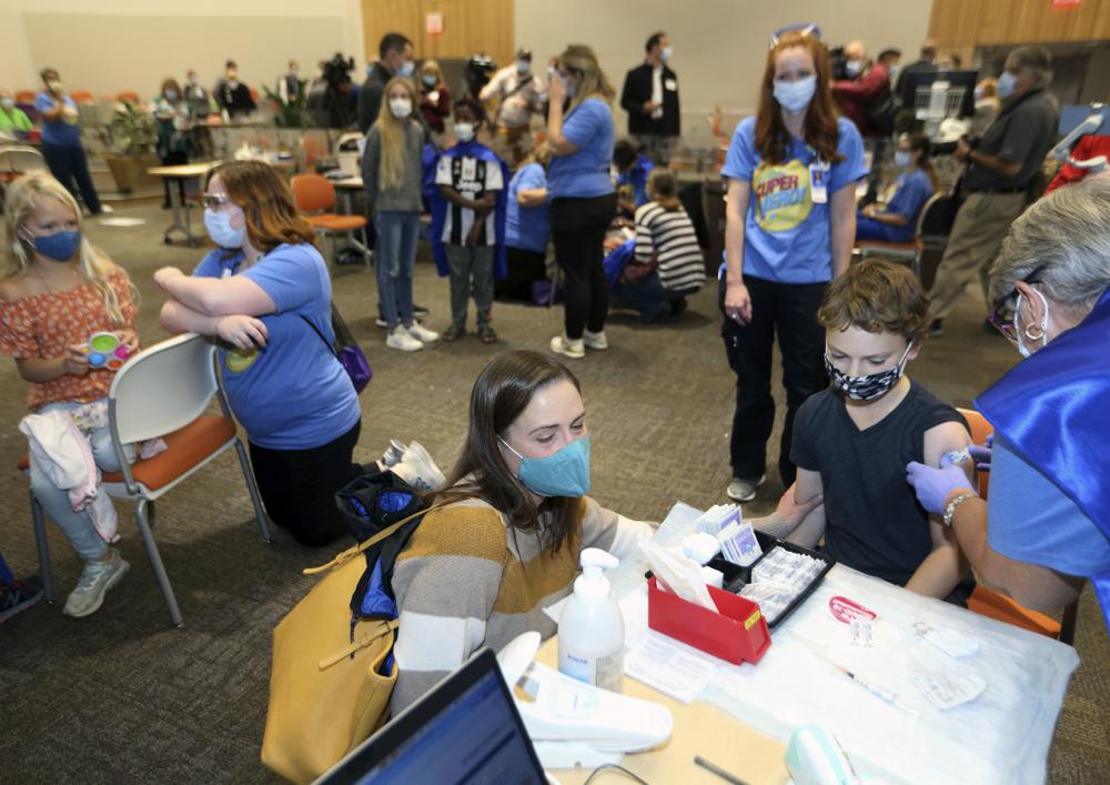 Retired registered nurse Jill Rill, right, puts a bandage on Jackson Stukus, 11, after he received a Pfizer COVID-19 vaccine as his mom Kristin looks on during the first COVID-19 vaccine clinic in Franklin County for children age 5-11 at Nationwide Children's Hospital in Columbus, Ohio, Nov. 3.