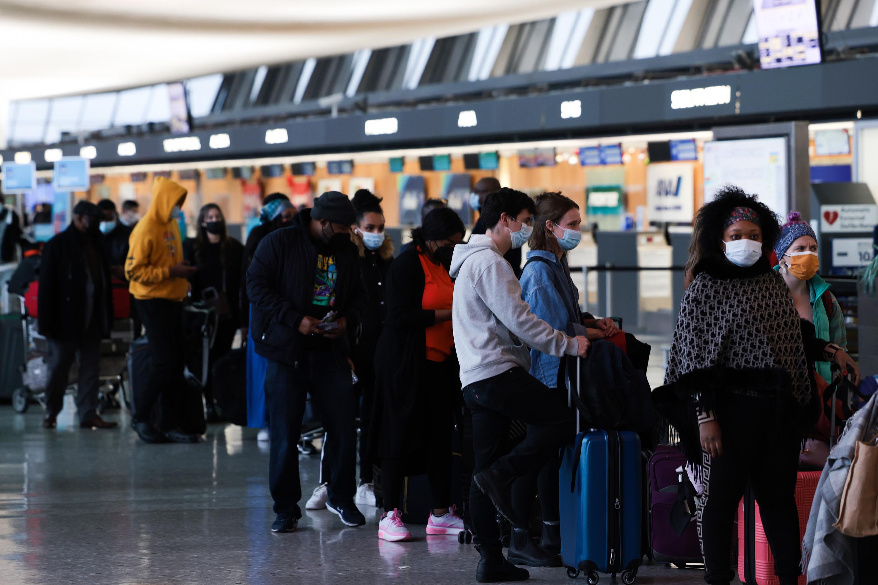 Passengers wait in line to check-in for their flights at the Dulles International Airport in Dulles, Virginia, on Monday.