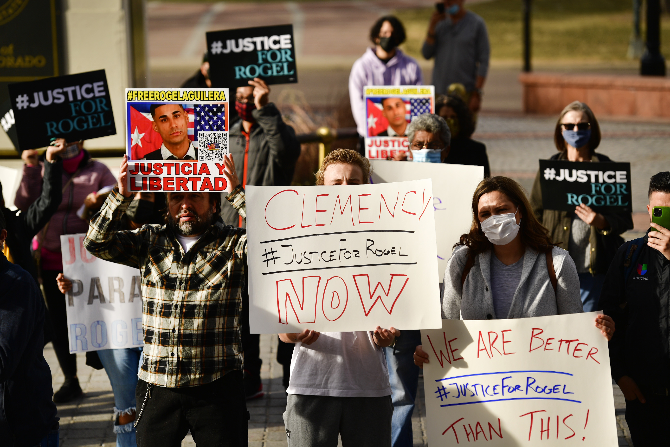 People hold signs in support of truck driver Rogel Aguilera-Mederos during a rally on the west steps of the state capitol on Dec. 22 in Denver.
