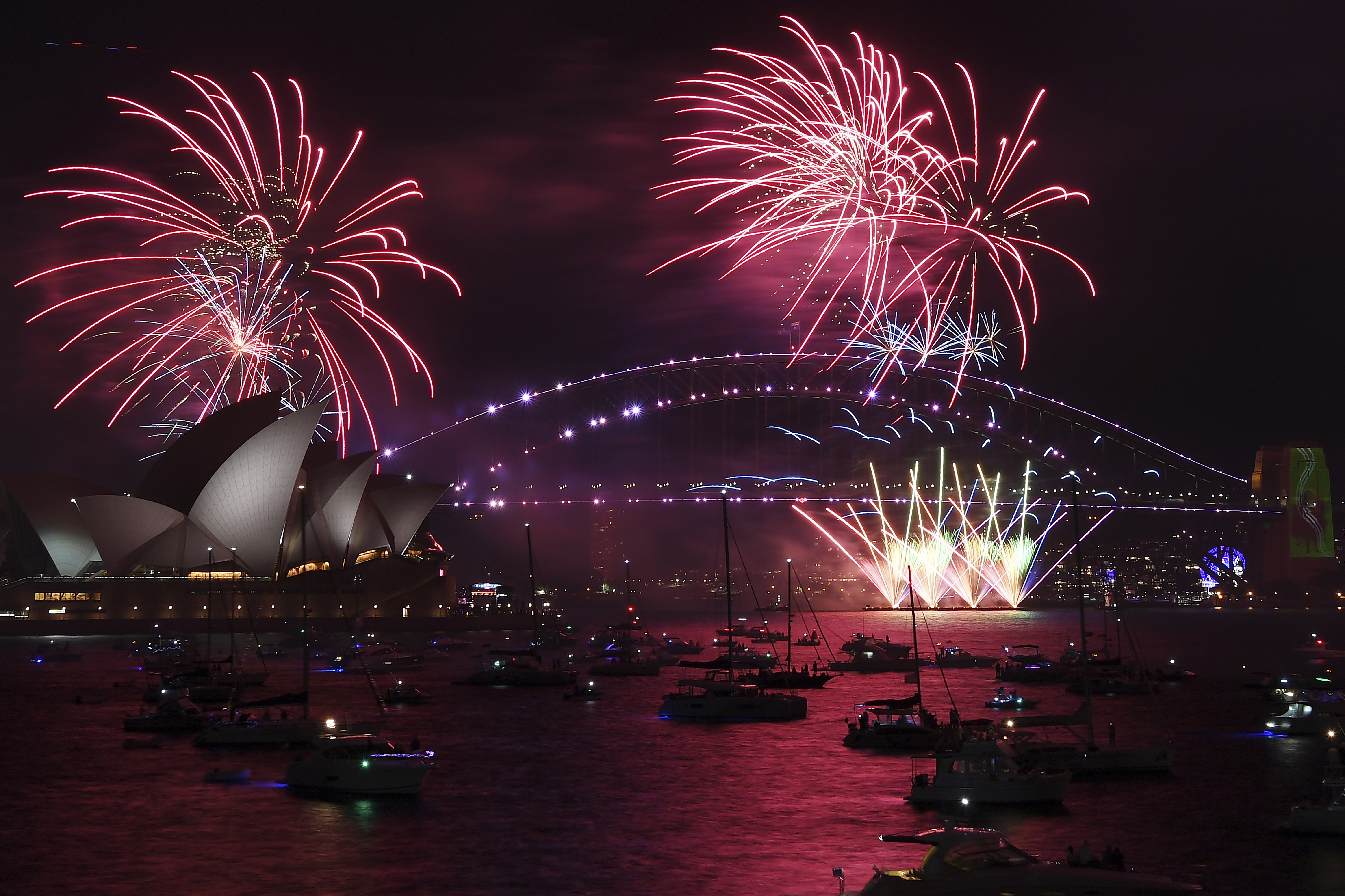 Fireworks explode over the Sydney Opera House and Harbour Bridge as New Year's Eve celebrations begin in Sydney, Friday.