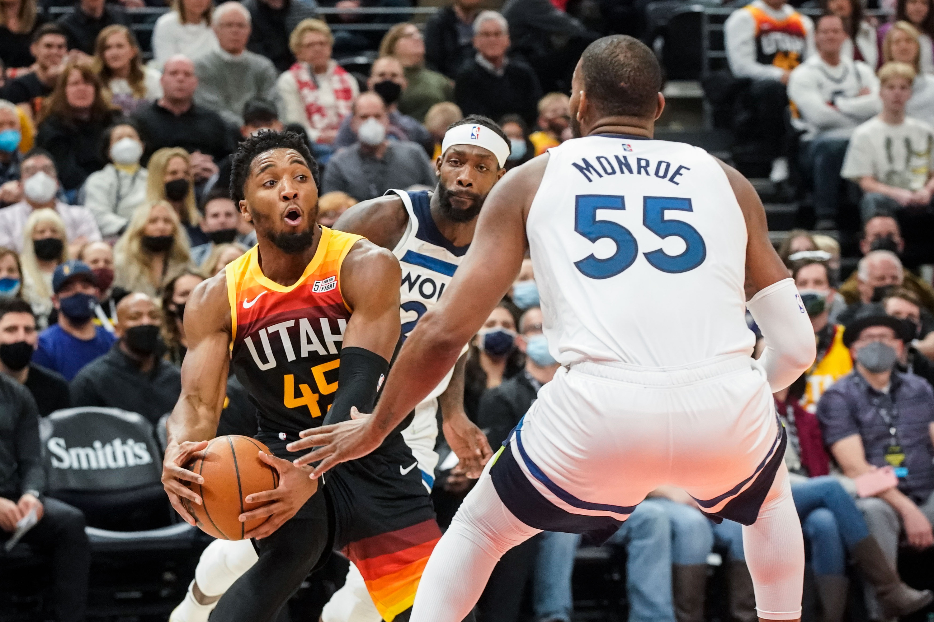 Utah Jazz guard Donovan Mitchell, left, looks to pass past Minnesota Timberwolves defenders during an NBA game at Vivint Arena in Salt Lake City on Friday, Dec. 31, 2021.