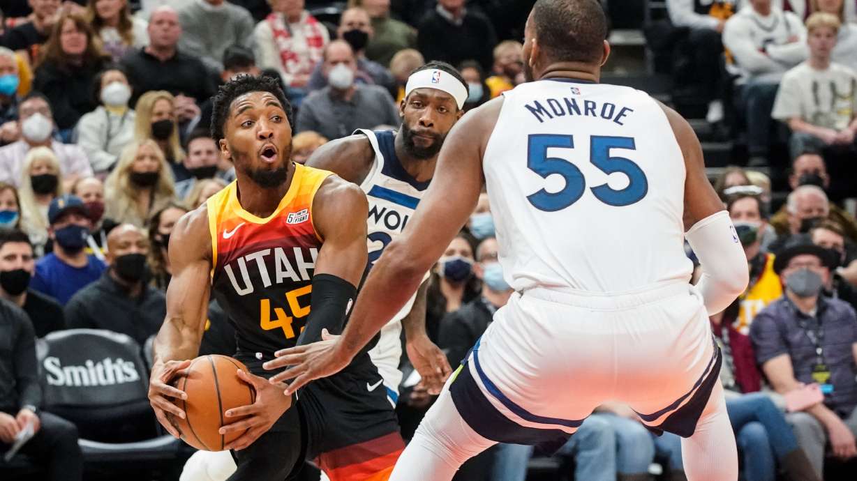 Utah Jazz guard Donovan Mitchell, left, looks to pass past Minnesota Timberwolves defenders during an NBA game at Vivint Arena in Salt Lake City on Friday, Dec. 31, 2021.
