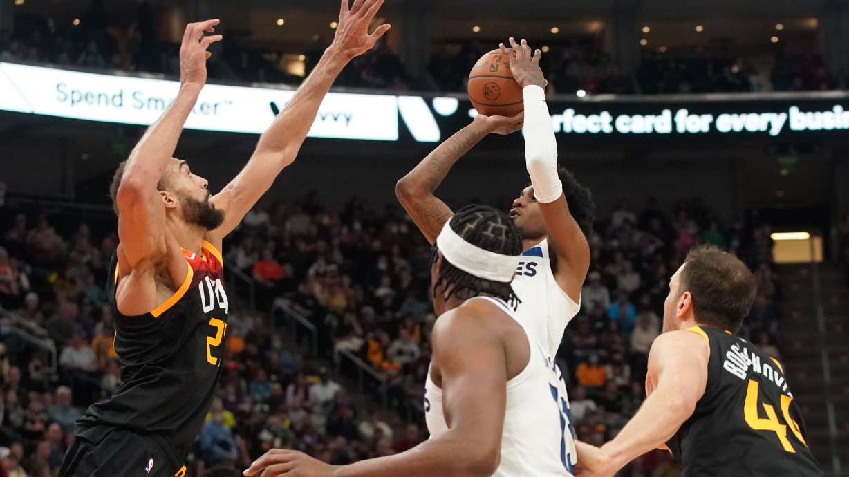 Minnesota Timberwolves forward Jaden McDaniels, right, attempts to shoot as Utah Jazz center Rudy Gobert attempts to block during an NBA game at Vivint Arena in Salt Lake City on Friday, Dec. 31, 2021.