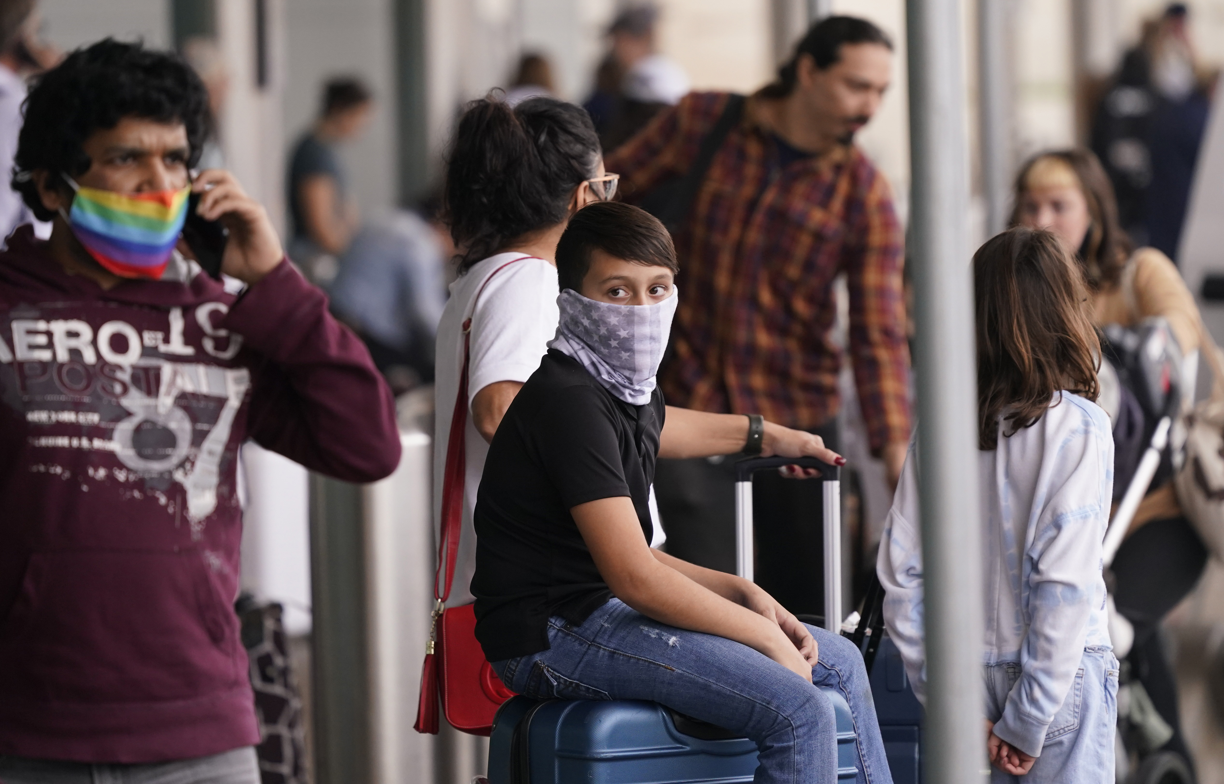 To prevent the spread of COVID-19, air travelers wear masks at Love Field in Dallas on Friday. Flight cancellations surged again on the last day of 2021, with airlines blaming wintry weather and high numbers of sickouts due to the rising number of COVID-19 infections around the country.  