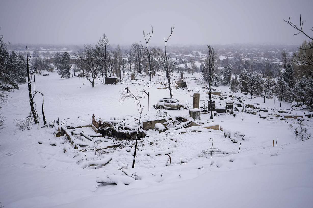 Snow covers the burned remains of homes in Louisville, Colo., on Saturday, after the Marshall Wildfire.