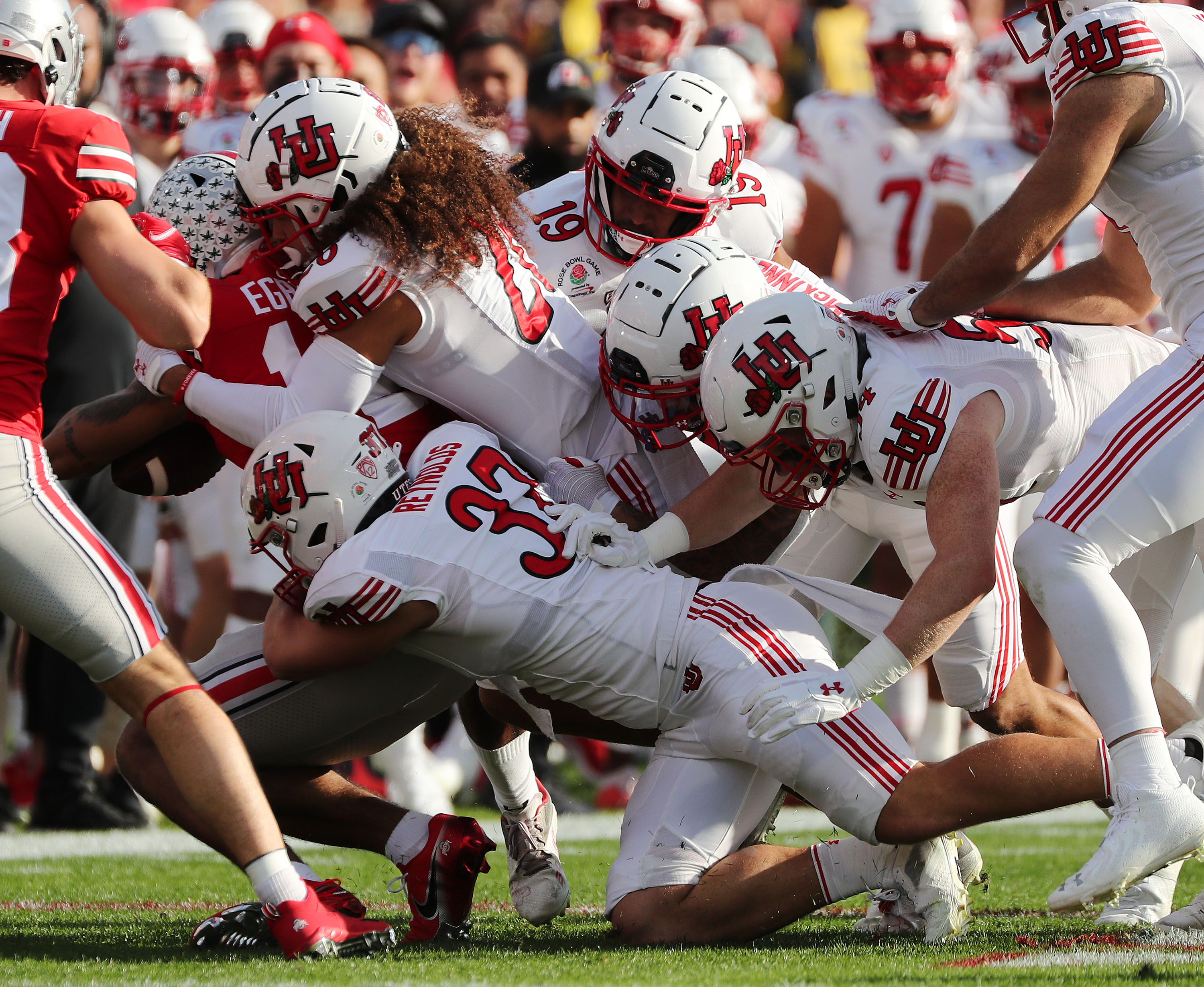 The Utah Utes defense gang tackle Ohio State Buckeyes wide receiver Emeka Egbuka (12) during the Rose Bowl in Pasadena on Saturday, Jan. 1, 2022. Utah leads 35-21 at half.