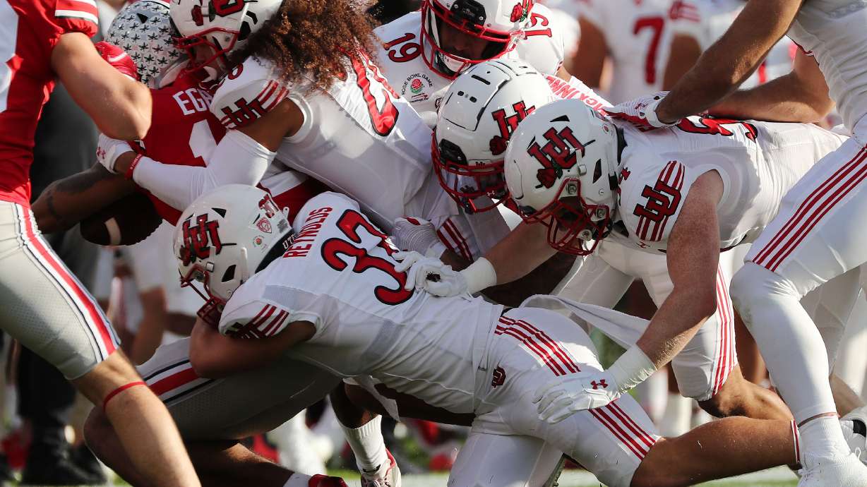 The Utah Utes defense gang tackle Ohio State Buckeyes wide receiver Emeka Egbuka (12) during the Rose Bowl in Pasadena on Saturday, Jan. 1, 2022. Utah leads 35-21 at half.