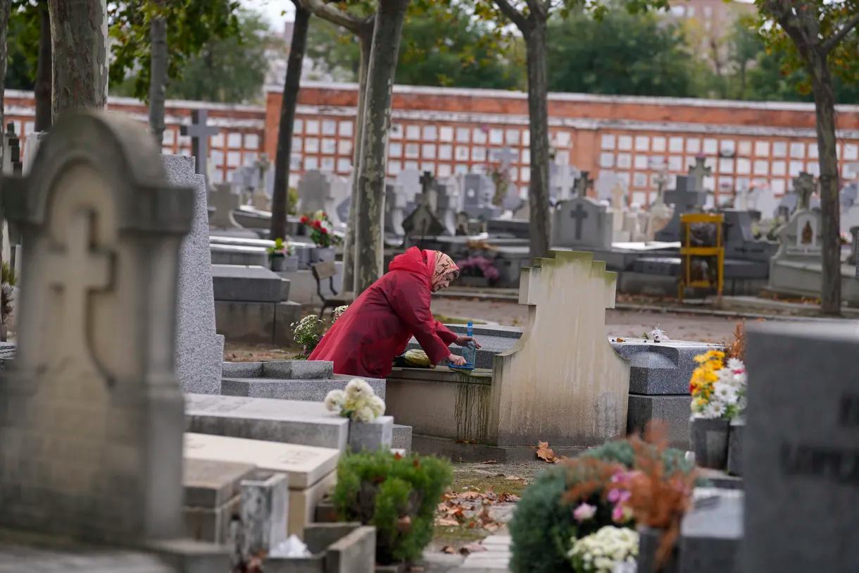 A woman cleans a relative’s tombstone in the Almudena cemetery a day before All Saints Day, a Catholic holiday to reflect on the saints and deceased relatives, in Madrid, Spain, Sunday, Oct. 31, 2021. 