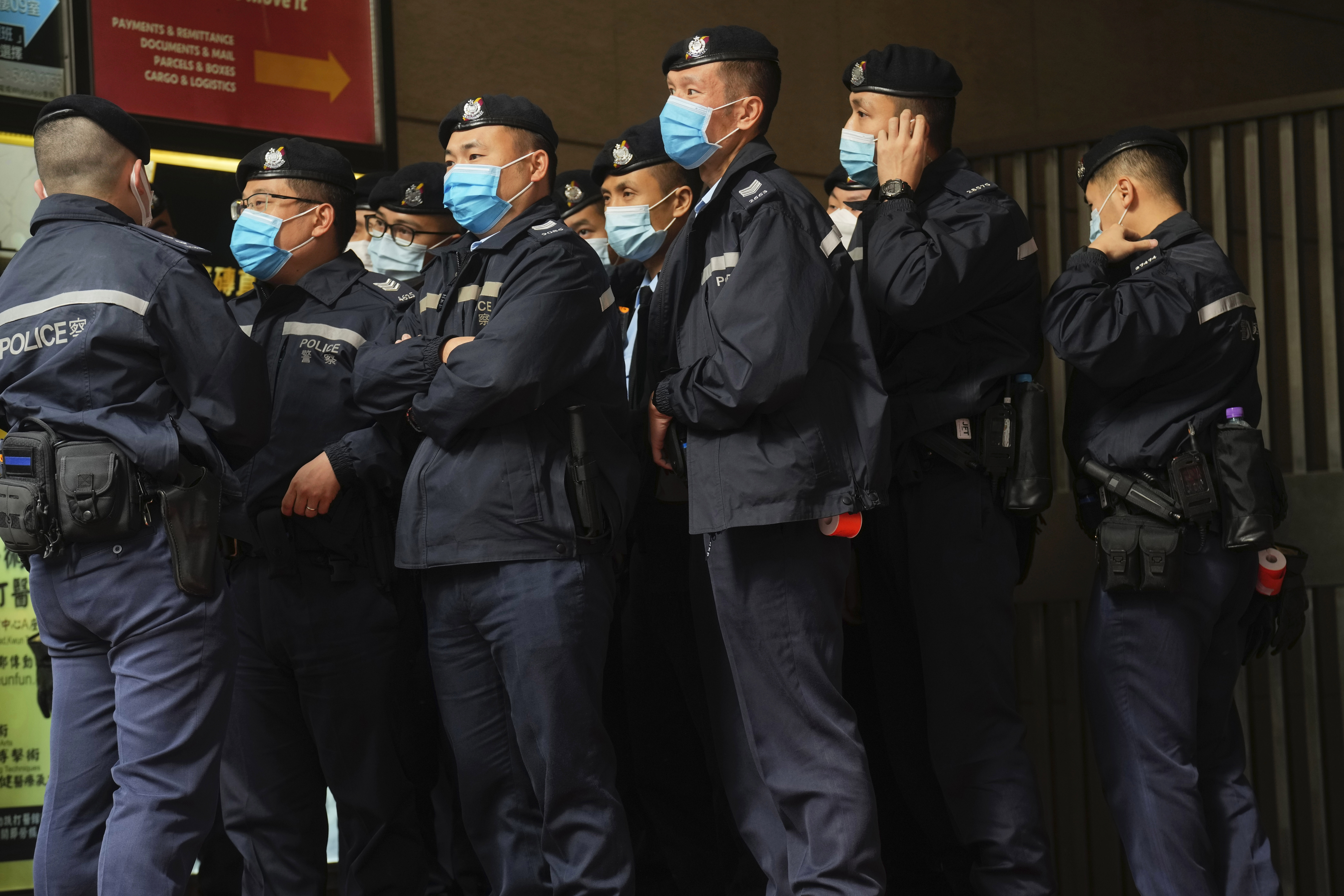 Police officers guard outside the building of Stand News' office in Hong Kong on Wednesday. Days after authorities raided Stand News and arrested seven people for allegedly conspiring to publish seditious material, Hong Kong online media outlet Citizen News said it would cease operations in light of deteriorating press freedoms.