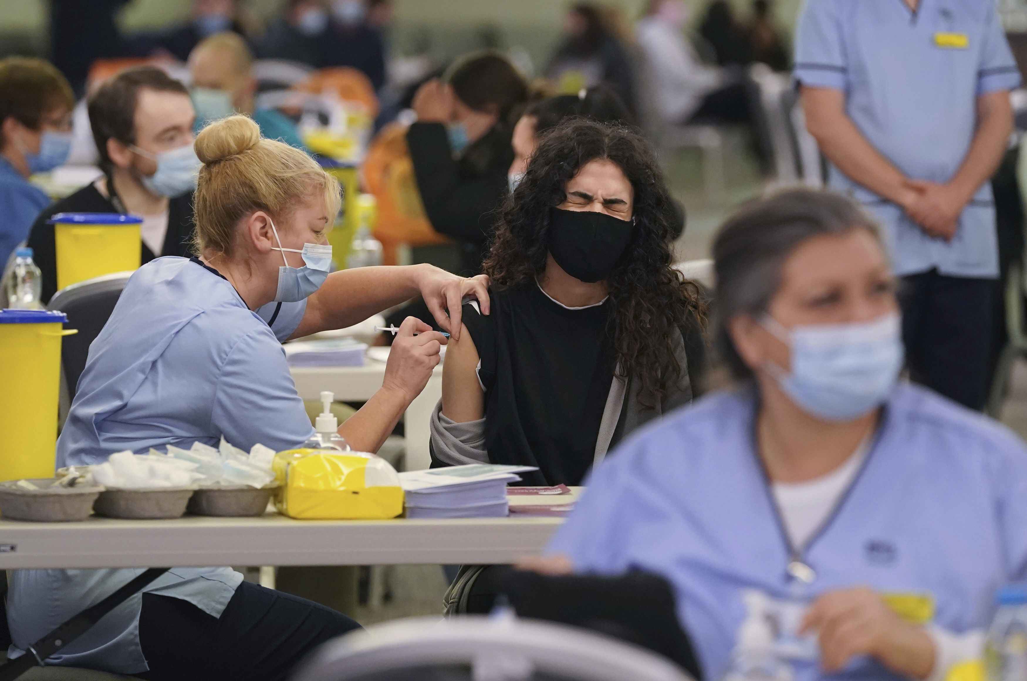 Ghadeer Mahar grimaces as she is given a vaccination at a COVID-19 booster vaccination centre at Hampden Park vaccination centre in Glasgow, Scotland on Wednesday.